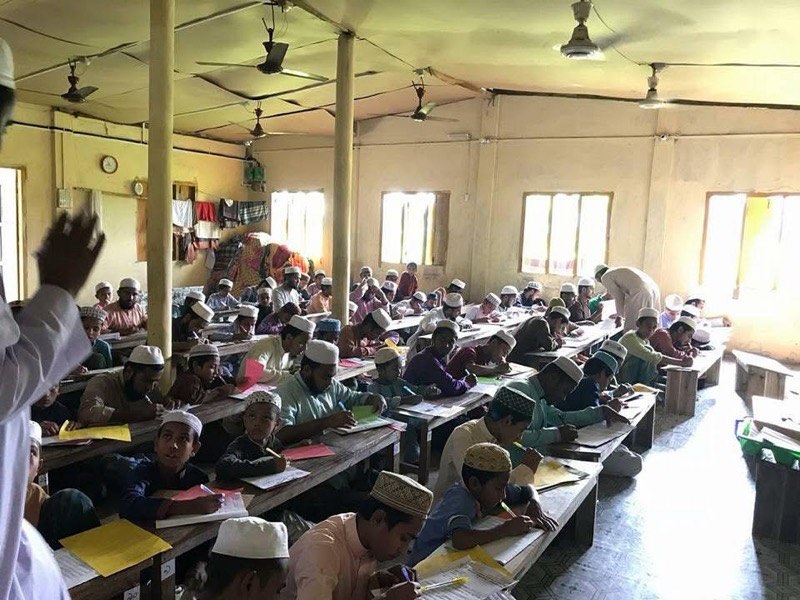 Students seated at benches during a lesson at the madrasah
